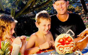 A man and 2 children are attending a fruit carving class at Grand Mirage Resort & Thalasso Bali